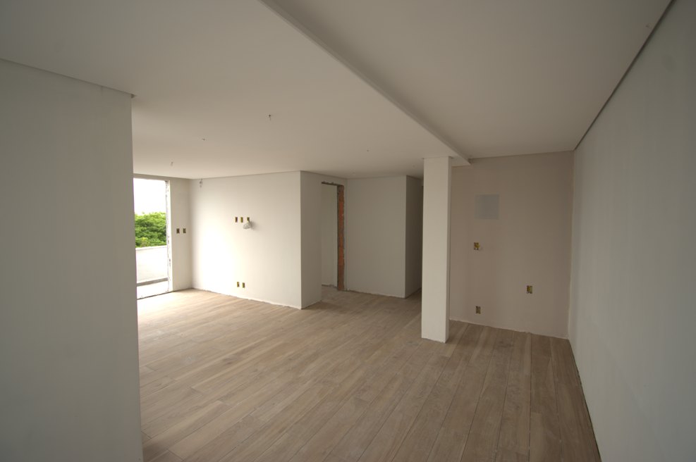 Ambiente depois da reforma, com forro em drywall, piso amadeirado e paredes lisas