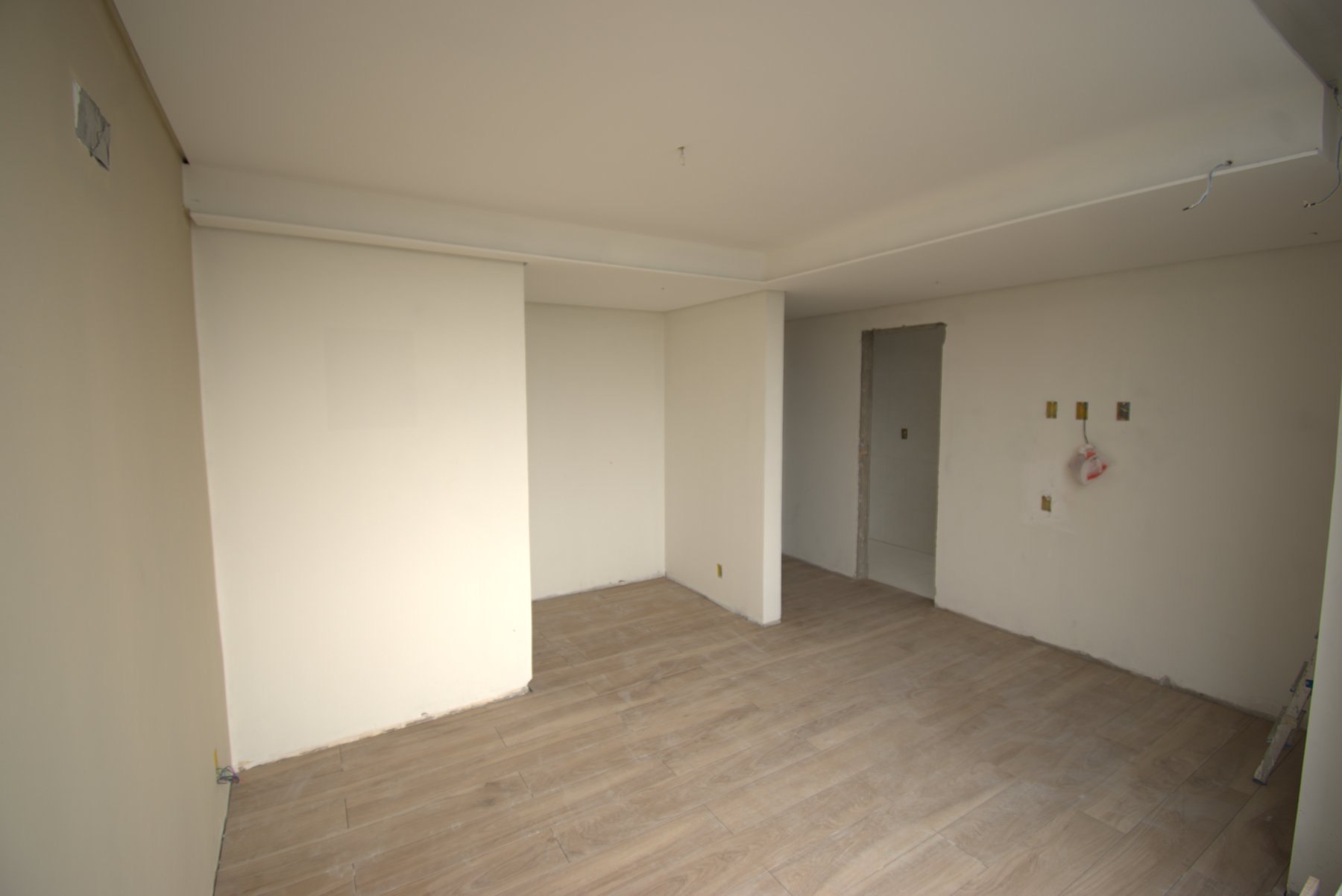 Ambiente depois da reforma, com forro em drywall, piso amadeirado e paredes lisas